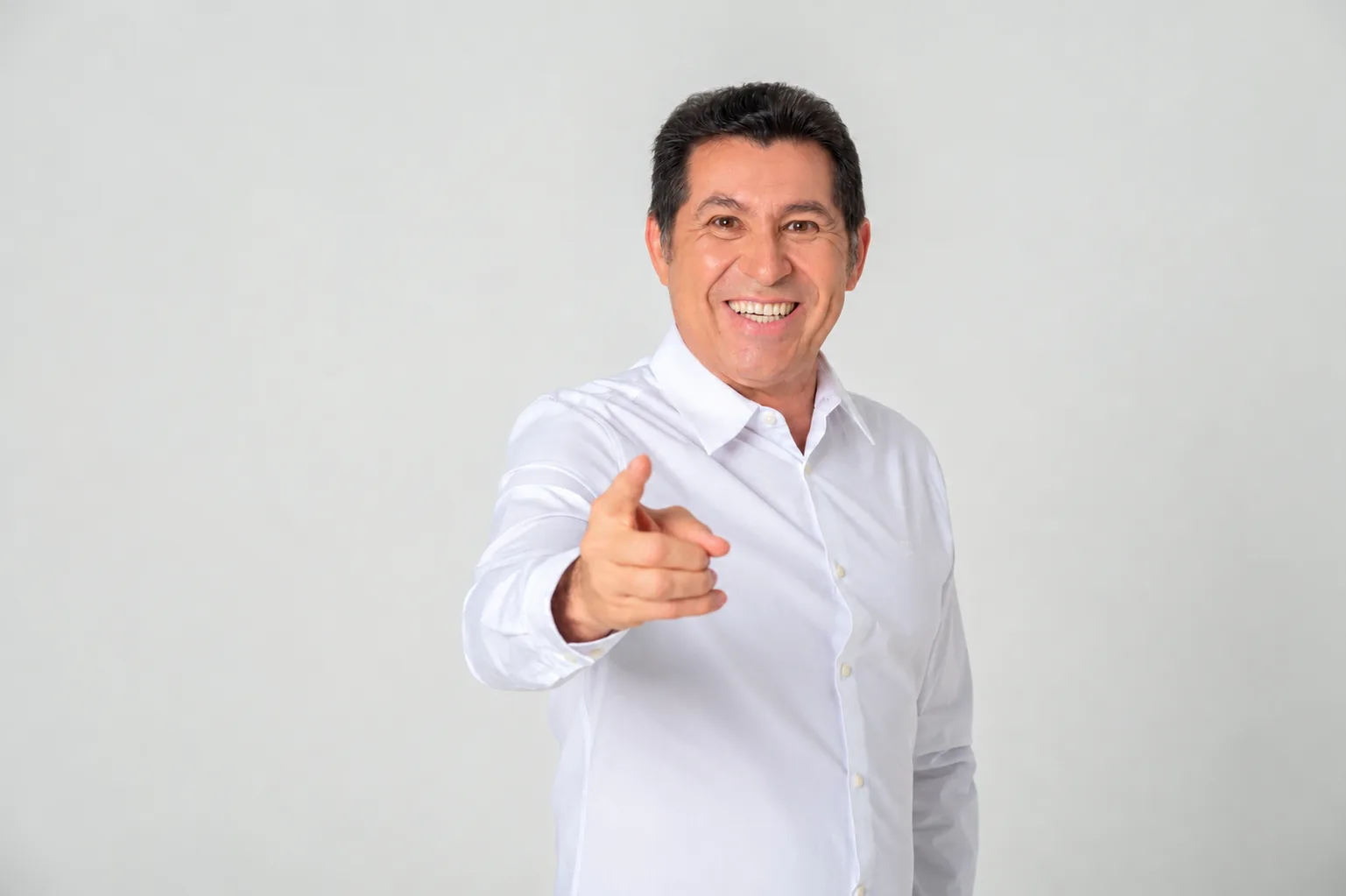De Assis Diniz de camisa branca, rindo e apontando